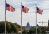 Three American flags waving in front of the Capitol building in Washington D.C.