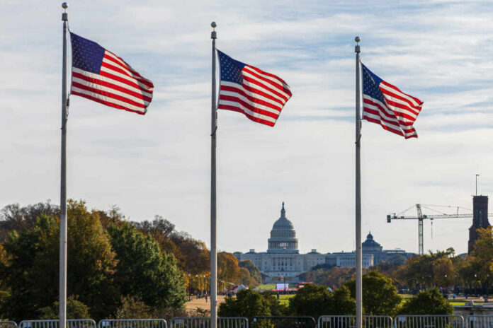 Three American flags waving in front of the Capitol building in Washington D.C.