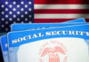 Social Security cards in front of the American flag