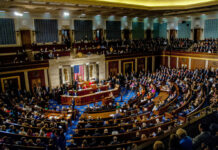National Security Cliff — Congress Plays Chicken A large gathering of officials in a congressional chamber during a legislative session