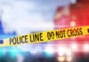 Yellow police tape reading DO NOT CROSS at a crime scene