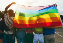 Group of people holding a rainbow flag during a pride celebration