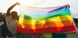 Group of people holding a rainbow flag during a pride celebration