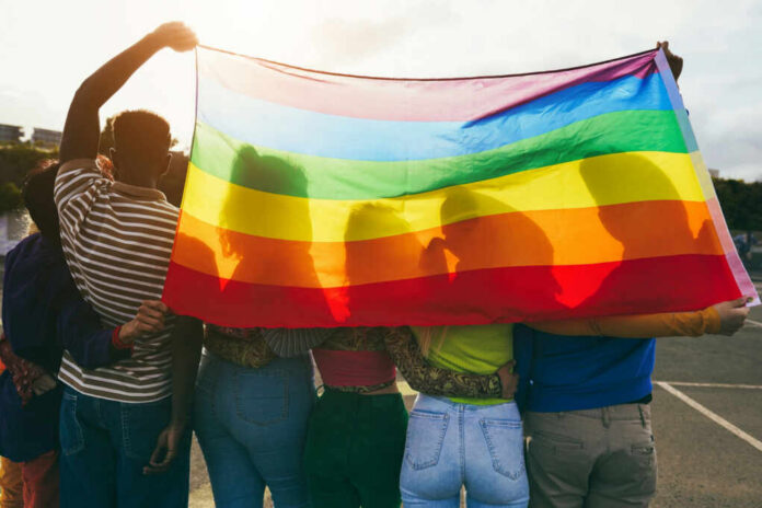 Group of people holding a rainbow flag during a pride celebration