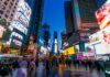 Crowd of people in Times Square surrounded by bright advertisements and buildings