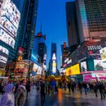 Crowd of people in Times Square surrounded by bright advertisements and buildings