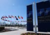 French NATO Jets Shoot Down Drone After It Breaches Latvian Airspace Flags of various nations displayed outside NATO headquarters under a clear blue sky