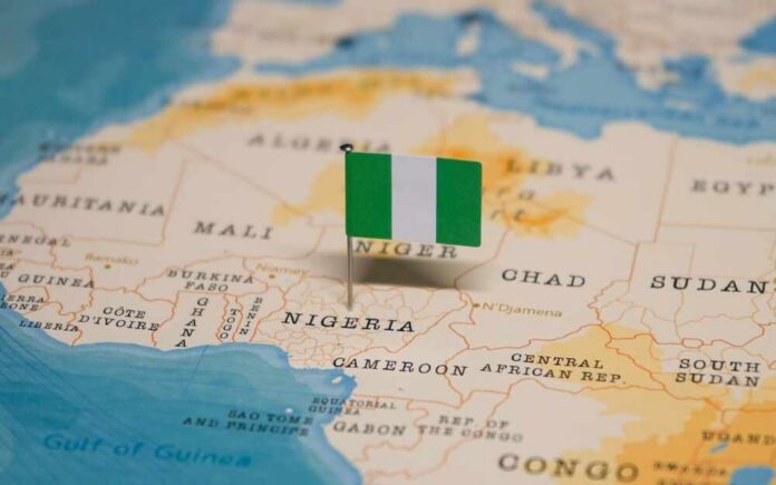 The,Map,And,Flag,Of,Nigeria. A small Nigerian flag placed on a map of Africa