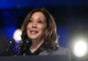 A female politician speaking at a podium with microphones in front of her