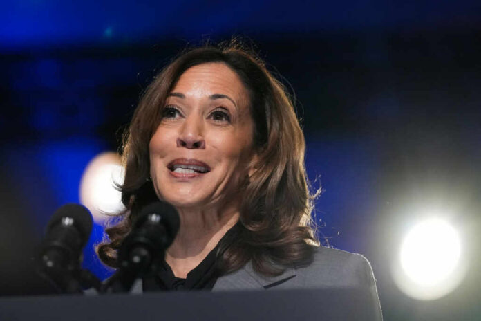A female politician speaking at a podium with microphones in front of her