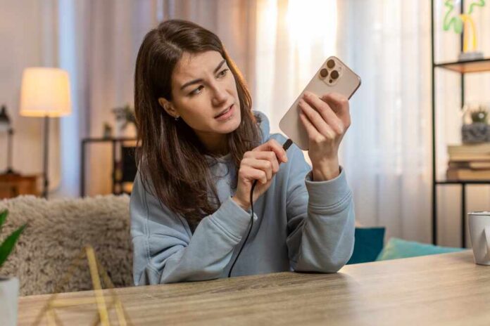 Young,Caucasian,Woman,Plugging,Charging,Cable,Into,Smartphone,And,Unplugging Various web browser tabs displaying logos of major tech companies