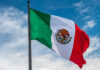 Stadium Routes CHOKED — Chaos Looms Waving Mexican flag against a blue sky