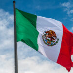 Waving Mexican flag against a blue sky