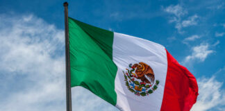 Waving Mexican flag against a blue sky