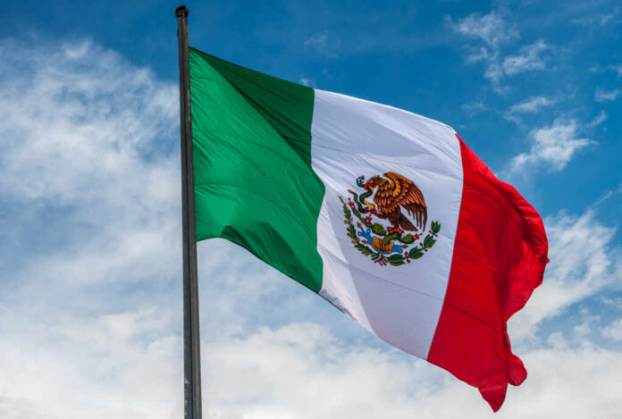 Flag,Of,Mexico,Over,Blue,Cloudy,Sky Waving Mexican flag against a blue sky