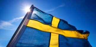 Asylum Shake-Up: Sweden Cuts Lifelines Swedish flag waving against a clear blue sky