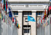 UN’s Bag Order Sparks Panic — Why? United Nations building with multiple international flags in front