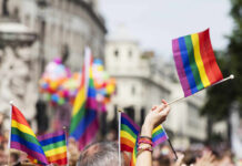 Crowd holding rainbow flags at a Pride parade