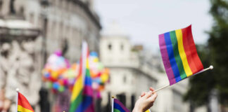 Crowd holding rainbow flags at a Pride parade