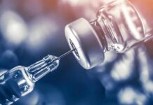 Singapore Lab Fast-Tracks Ebola Defense syringe needle drawing liquid from a vaccine vial