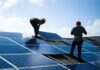 Workers installing solar panels on a rooftop