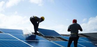 Sun-Soaked Clubhouse Cuts Bills — Mandate-Free Workers installing solar panels on a rooftop
