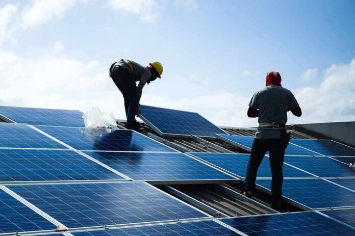 Workers installing solar panels on a rooftop