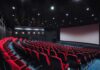 empty movie theater with red seats and large screen