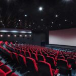 empty movie theater with red seats and large screen
