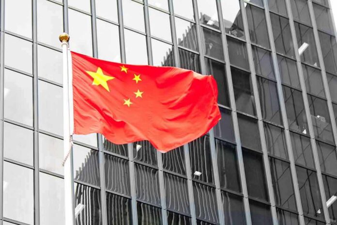 Chinese flag waving against glass office building