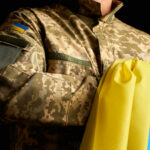 Brussels’ War Filter Targets Young Men A soldier in a camouflage uniform holding a Ukrainian flag
