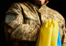 Brussels’ War Filter Targets Young Men A soldier in a camouflage uniform holding a Ukrainian flag