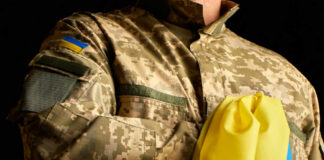 Brussels’ War Filter Targets Young Men A soldier in a camouflage uniform holding a Ukrainian flag