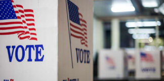 Power Grab Or Fix? Election Board Gutted Voting booths with American flags in a polling station
