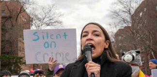 woman speaking into a microphone at an outdoor protest