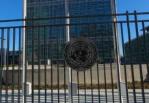 UN Inferno, Silence — What’s Being Hidden? United Nations building with multiple international flags in front