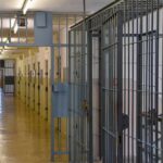 Prison corridor with barred doors