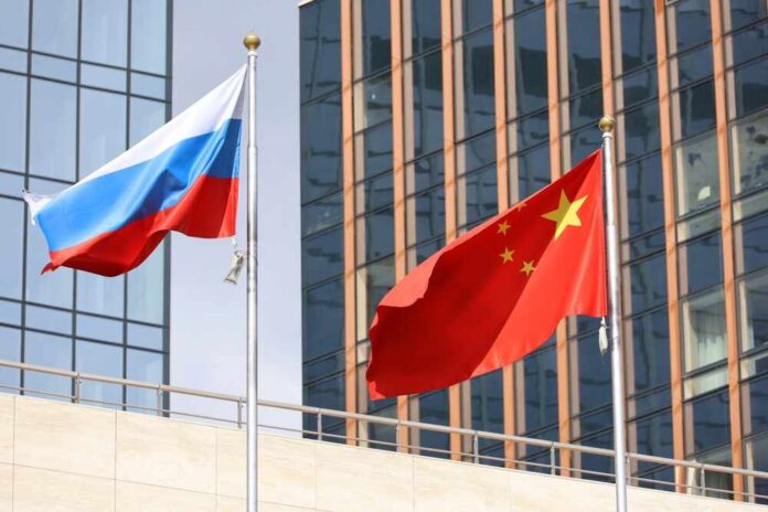 Flags,Of,China,And,Russia,On,Skyscrapers,Background.,Concept,Of A fleet of military ships sailing in the ocean