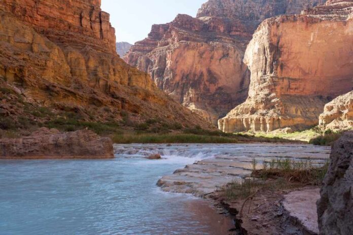 Little,Colorado,River,,Az-,June,22,2022:,Lcr,Running,Through,The Arizona state flag waving against a bright sky