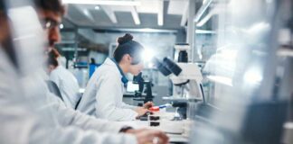 Diarrhea Outbreak Sparks Taco Bell Pullback Scientists working in a laboratory with microscopes and test tubes