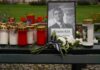 Memorial setup with candles, flowers, and a framed photograph