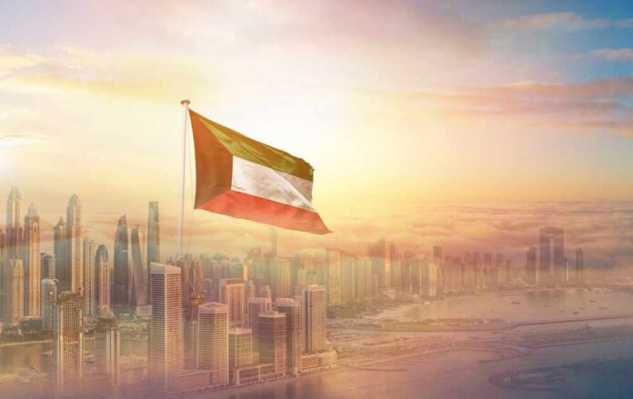 Kuwait flag flying over a modern city skyline at sunrise