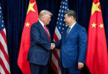 China Cries Bullying—The Real Pain Starts Next Two political leaders shaking hands in front of national flags