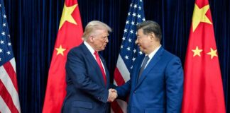 China Cries Bullying—The Real Pain Starts Next Two political leaders shaking hands in front of national flags