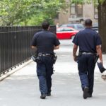 Two police officers walking on a city sidewalk