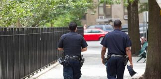 Two police officers walking on a city sidewalk