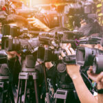 A crowd of journalists with cameras capturing an event