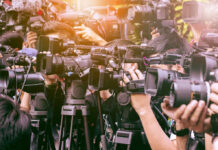 A crowd of journalists with cameras capturing an event