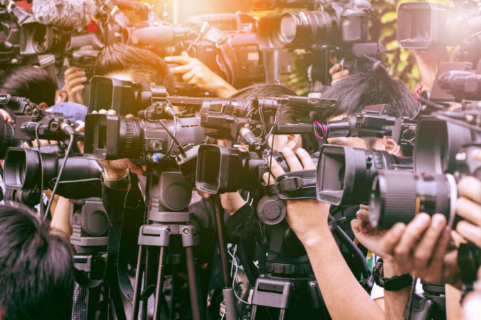 A crowd of journalists with cameras capturing an event