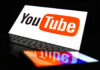 YouTube logo on a laptop and smartphone screen.